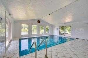 een groot zwembad in een witte kamer met ramen bij Missouri Castle with Private Lake, Pool and 100 Acres! in Avon