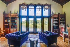 uma sala de estar com sofás azuis e uma grande janela em Missouri Castle with Private Lake, Pool and 100 Acres! em Avon