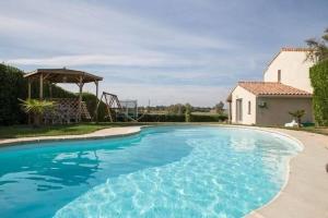 a large blue swimming pool next to a house at Le joyaux d'ambre in La Pomarède