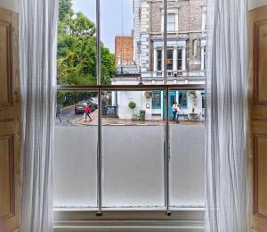 a window with a view of a city street at Adorable Apartment in The Heart of Primrose Hill in London