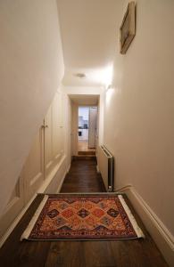 an empty hallway with a rug on the floor at Adorable Apartment in The Heart of Primrose Hill in London