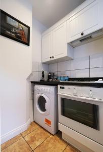 a kitchen with a washing machine and a washer at Adorable Apartment in The Heart of Primrose Hill in London