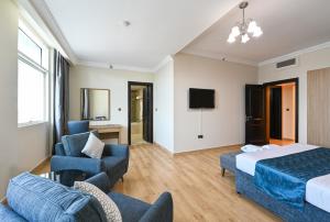 una camera d'albergo con letto, divano e sedie di Saray Musheireb Hotel and Suites a Doha