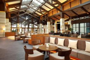 a lobby with couches and tables and chairs at DoubleTree By Hilton Jiaxing in Jiaxing