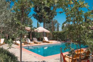 una piscina en un complejo con tumbonas y árboles en Villa Cesi Resort & Spa en Impruneta