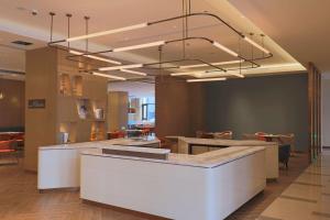 a lobby with a restaurant with a large chandelier at Hilton Garden Inn Changzhou Jintan in Changzhou