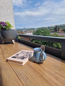 un libro y una taza sobre una mesa en un balcón en Apartmán RedDog, en Košice