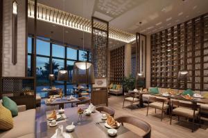 um restaurante com mesas e cadeiras num quarto em Doubletree Resort By Hilton Hainan - Xinglong Lakeside em Wanning