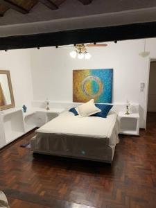 a bedroom with a bed and a painting on the wall at Quinta Las Amintas in Berna +44 photos