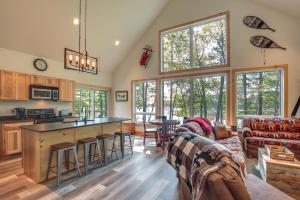 a kitchen and living room with a couch and a table at Cozy Northwoods Cabin with Private Lake Access in Eagle River