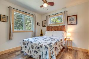 a bedroom with a bed and two windows at Cozy Northwoods Cabin with Private Lake Access in Eagle River