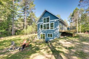 a blue tiny house in the middle of a yard at Cozy Northwoods Cabin with Private Lake Access in Eagle River