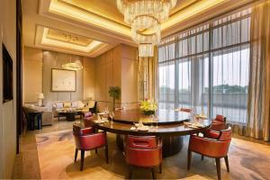 DoubleTree By Hilton Ningbo Beilun في نينغبو: غرفة طعام مع طاولة وكراسي ونافذة كبيرة