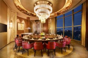 a dining room with a large table and red chairs at DoubleTree By Hilton Ningbo Beilun in Ningbo