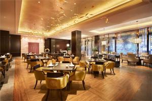 um restaurante com mesas e cadeiras num quarto em DoubleTree By Hilton Ningbo Beilun em Ningbo