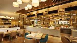宁波宁波北仑世茂希尔顿逸林酒店的有桌椅和酒吧的餐厅 更多37张照片