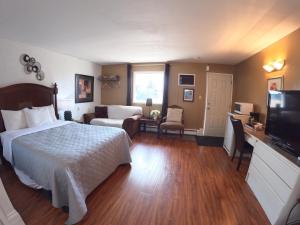 a hotel room with a bed and a television at Westview Motel in Vegreville