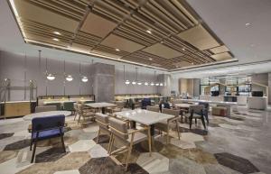 a restaurant with tables and chairs in a room at Hilton Garden Inn Xingtai Xiangdu District in Ta-liang-chuang