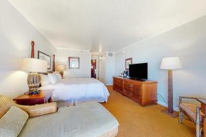 a bedroom with a bed and a tv and a couch at Condos in Kauai Beach Resort in Hanamaulu