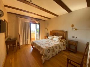 a bedroom with a bed and a table and a window at Hotel Rural Centro de las Arribes in Aldeadávila de la Ribera