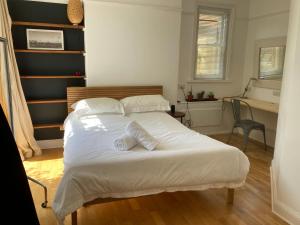 a bedroom with a bed with white sheets and pillows at The Vineyard (Home of the think pod) in Portsmouth