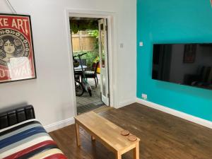 a living room with a couch and a flat screen tv at The Vineyard (Home of the think pod) in Portsmouth