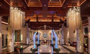 a lobby with a large clock in the center of a building at Hilton Qingdao Golden Beach - Beer Halls in Huangdao