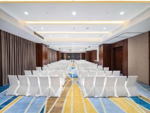 an empty room with white chairs in a row at Hilton Garden Inn Chengdu Huayang in Chengdu