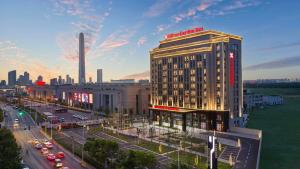 ein hohes Gebäude in einer Stadtstraße mit Verkehr in der Unterkunft Hilton Garden Inn Tianjin Huayuan in Tianjin
