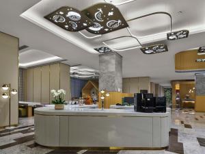 a lobby with a reception desk in a building at Hilton Garden Inn Tianjin Huayuan in Tianjin