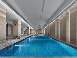 Doubletree By Hilton Baoding في Baoding: مسبح في لوبي الفندق مع مسبح ازرق كبير