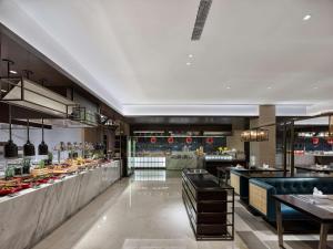 a restaurant with a large kitchen with many tables at Doubletree By Hilton Baoding in Baoding