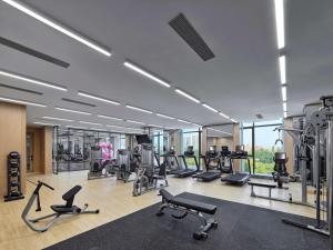een fitnessruimte met diverse loopbanden en hometrainers bij Doubletree By Hilton Baoding in Baoding