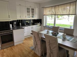 a kitchen with a wooden table with chairs and a dining room at Pråmkanalens Pensionat i Karlstad in Karlstad