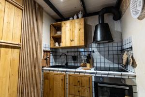 a kitchen with wooden cabinets and a stove top oven at La Scunnuta Apartment in Pulsano