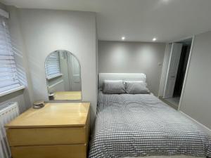 a small bedroom with a bed and a mirror at The Greig 2 in Wadhurst