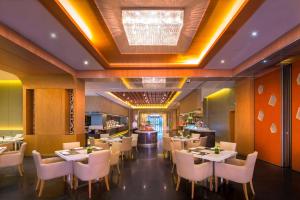 a restaurant with white tables and white chairs at DoubleTree by Hilton Ningbo - Chunxiao in Ningbo