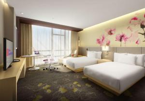 a hotel room with two beds and a tv at Hilton Garden Inn Guiyang Yunyan in Guiyang