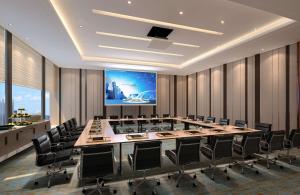 une salle de conférence avec une grande table et des chaises dans l'établissement Hilton Garden Inn Guiyang Yunyan, à Guiyang
