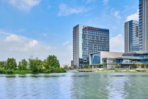 vista su un fiume di fronte ad alcuni edifici di Hilton Garden Inn Suzhou Wuzhong a Suzhou