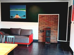 a living room with a couch and a brick fireplace at holiday home, Nowe Warpno in Nowe Warpno