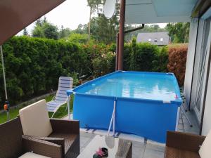 a large blue pool on a patio with chairs at Holiday house with swimming pool in Morzyczyn in Morzyczyn