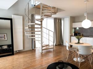 uma escada em espiral numa sala de estar com uma mesa em Duplex, spacious holiday apartment, summer swimming pool, Pogorzelica em Pogorzelica