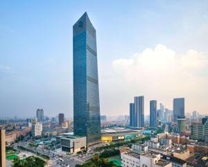un rascacielos de cristal alto en una gran ciudad en Conrad Shenyang, en Shenyang