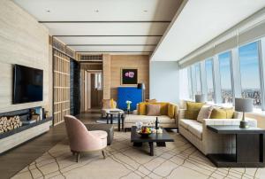 a living room with a couch and a tv at Conrad Shenyang in Shenyang