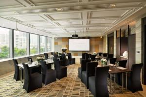 a dining room with tables and chairs and a screen at Conrad Shenyang in Shenyang +125 photos