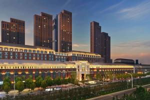 a large building in front of a city with tall buildings at Conrad Tianjin in Tianjin