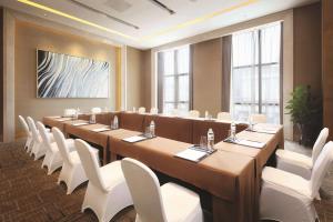 una gran sala de conferencias con una mesa larga y sillas blancas en DoubleTree by Hilton Chongqing Wanzhou, en Wanzhou