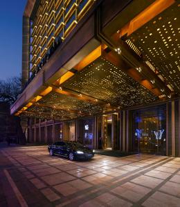 a car parked in front of a building with lights at Waldorf Astoria Beijing in Beijing