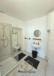 ein Bad mit einer Dusche und einem Waschbecken in der Unterkunft Bird Home Room 9 in Klagenfurt am Wörthersee